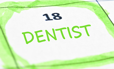 The image shows a calendar with the word  dentist  highlighted on the 18th day, which is circled in green marker. It appears to be a personal reminder for an upcoming dental appointment.