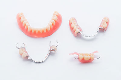 The image displays three pairs of dentures with visible teeth, presented on a white background.