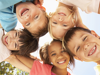 A group of children posing together with smiles on their faces.